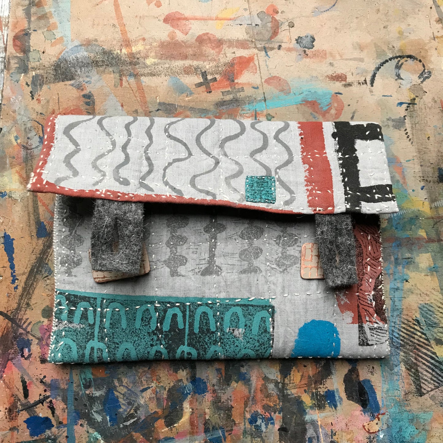 the PALE GREY pouch with textured buttons